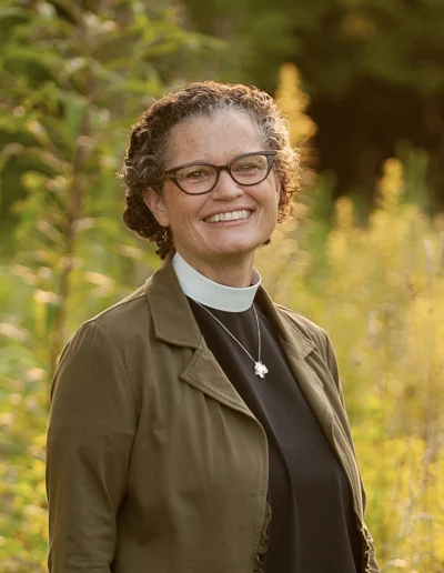 Bishop Phyllis A. Spiegel smiling in a field of greenery