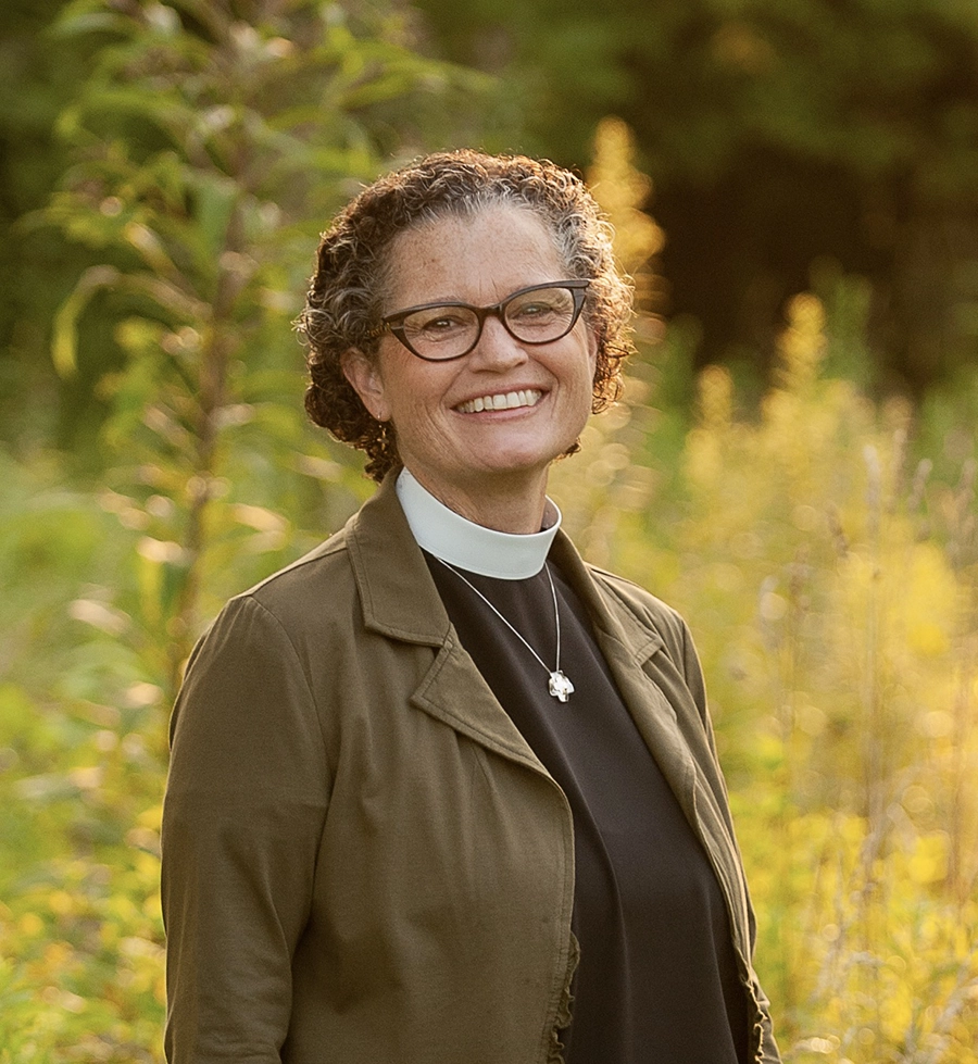 Bishop Phyllis A. Spiegel smiling in a field of greenery