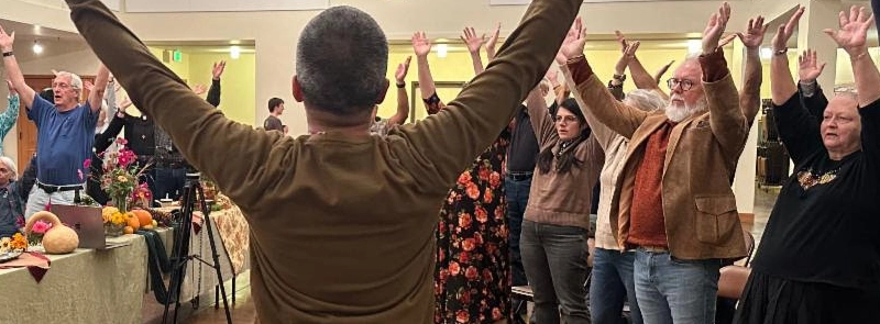 events Church event with attendees raising their arms in praise.